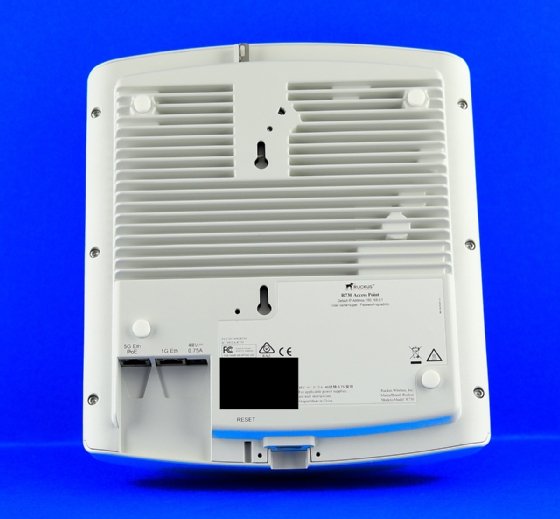 Abbildung 2: Der Wi-Fi-6-AP Ruckus R730 wirkt von vorne betont unauffällig. Hinten sieht man die Metall-Kühlrippen. Links unten im Foto die 5-Gigabit-Multi-Speed-Ethernet-Buchse