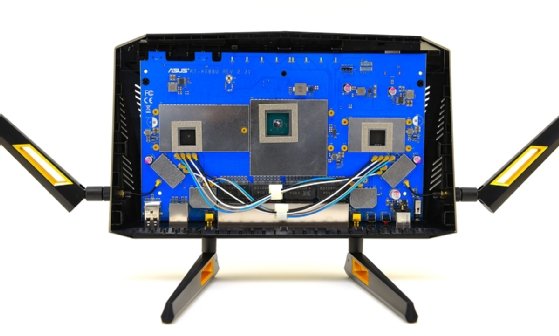 Innenleben eines Wi-Fi-6-Routers Asus RT-AX88U. Unter den bereits abgeschraubten Kühlplatten sieht man drei fingernagelgroße Prozessoren: Links der Ethernet-Switch Broadcom BCM53134. Mittig die Haupt-CPU Broadcom BMC4908. Rechts der WLAN-Chip Broadcom BCM43684