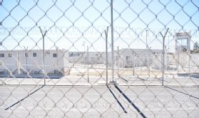Image shows fence and secure entrance at refugee camp on Samos Island, described by critics as “prison-like” and a “dystopian nightmare”