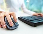 Woman typing at keyboard with computer mouse