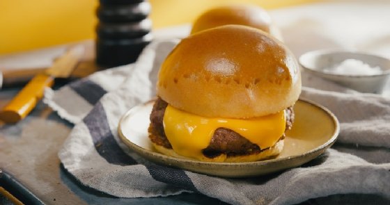 Photo of an Impossible Burger with melted cheese on a thick bun